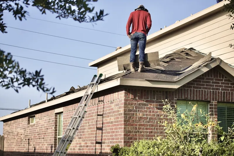 Professional roofer working on a residential roof in Brookwood Village